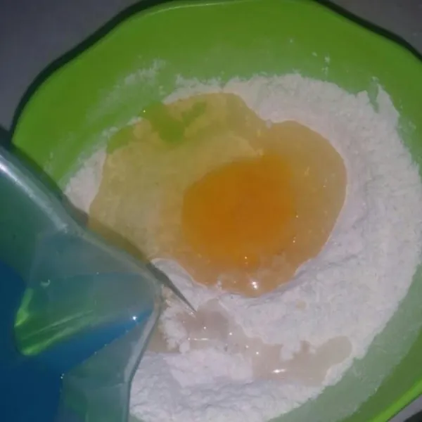 Tambahkan telur dan air, aduk menggunakan whisk sampai membentuk adonan jangan terlalu encer.