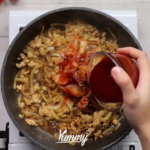 Masukkan kimchi dan gochujang ke dalam pan, aduk hingga merata dan harum.