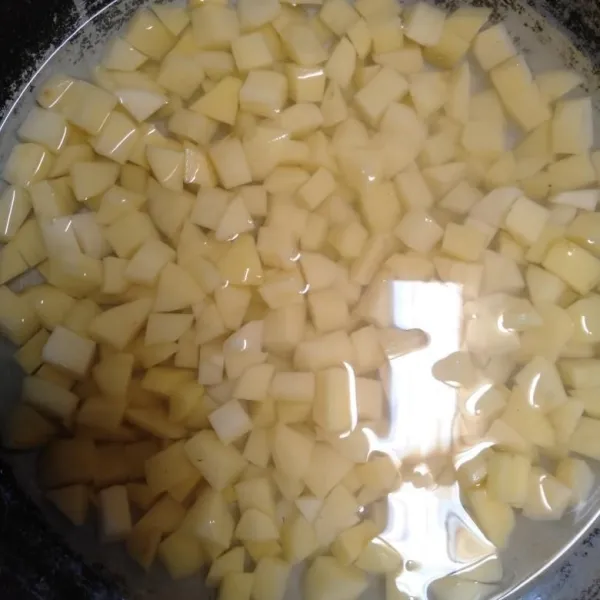 Potong-potong kentang seperti dadu kemudian rendam dalam air garam selama 15 menit.