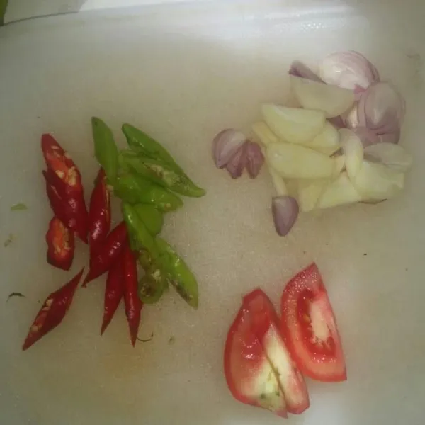Potong-potong bawang merah, bawang putih, cabe rawit, dan tomat.
