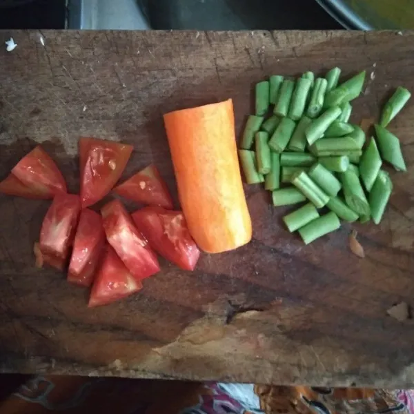 Potong buncis dan tomat, wortel cukup kupas kulitnya saja.