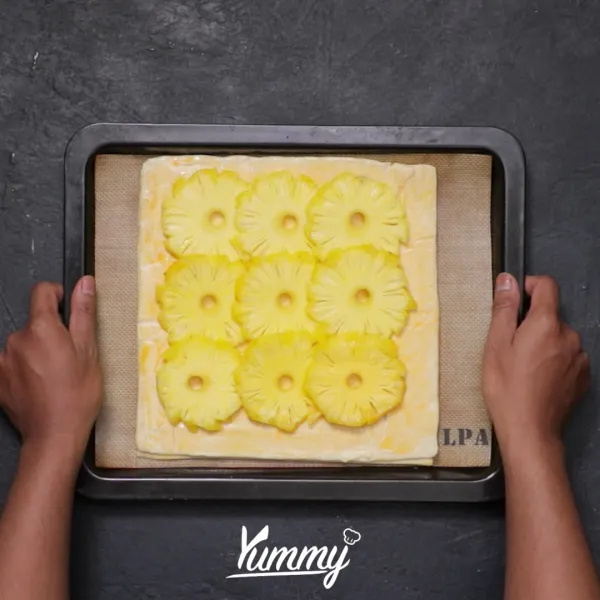 Letakkan nanas berbaris di bagian tengah lalu taburkan dengan gula pasir.