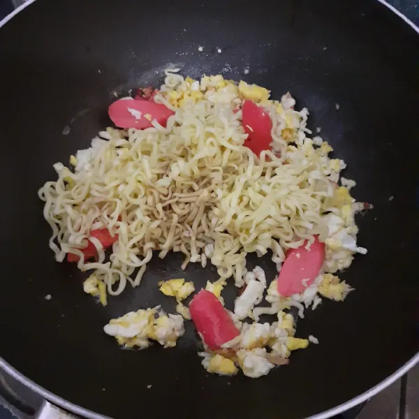 Tambahkan sosis dan mie kuning yang telah direbus.