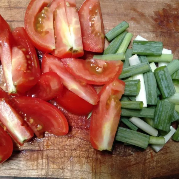 Potong-potong tomat dan daun bawang.