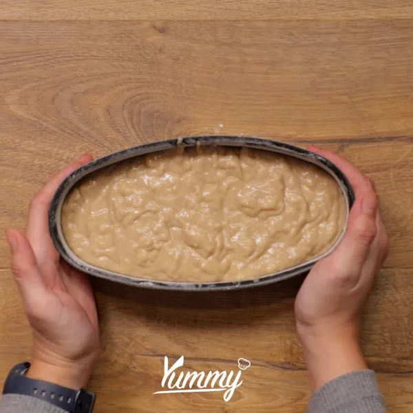 Siapkan loyang yang sudah diberi lapisan mentega dan tepung, tuangkan adonan ke dalamnya. Taburkan crumble di atasnya.