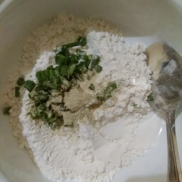 Masukkan tepung terigu, kaldu jamur bubuk, dan daun bawang ke dalam mangkok.