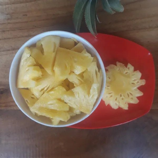 Kupas dan potong-potong buah nanas.