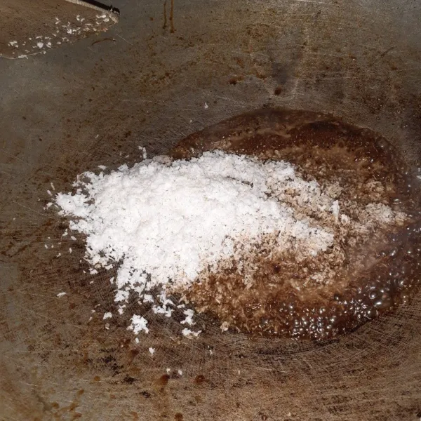 Jika sudah mencair, masukkan kelapa parut, sedikit garam, lalu aduk.