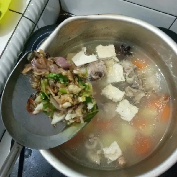 Masukkan bumbu halus ke dalam sup lalu aduk rata, kemudian tambahkan penyedap rasa ayam dan garam sesuai selera.