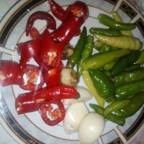 Siapkan 20 buah cabe rawit, 2 buah cabe merah iris kecil-kecil, 2 siung bawang putih, dan 1 cm jahe.