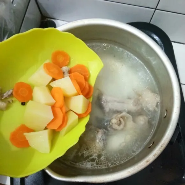 Setelah ayam sudah setengah matang, masukkan kentang dan wortel.