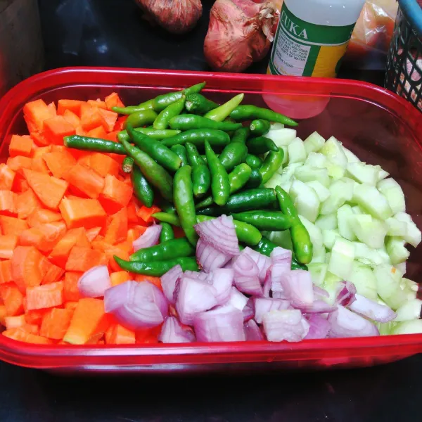 Potong dadu wortel dan bawang merah, buang tangkai cabai, buang isi ketimun kemudian potong panjang agak tipis.