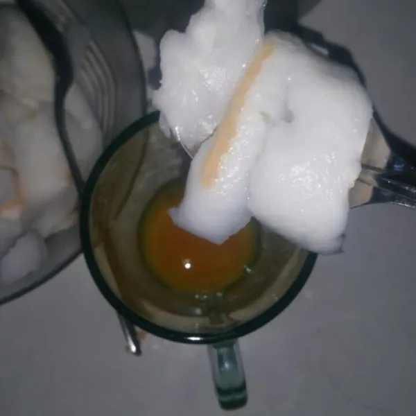 Tuang perasan air jeruk pada gelas, kemudian campurkan daging kelapa.