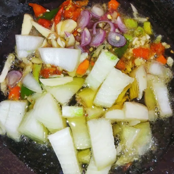 Panaskan minyak goreng kemudian tumis bawang putih, bawang merah, bawang bombay, rawit, dan daun jeruk hingga harum.