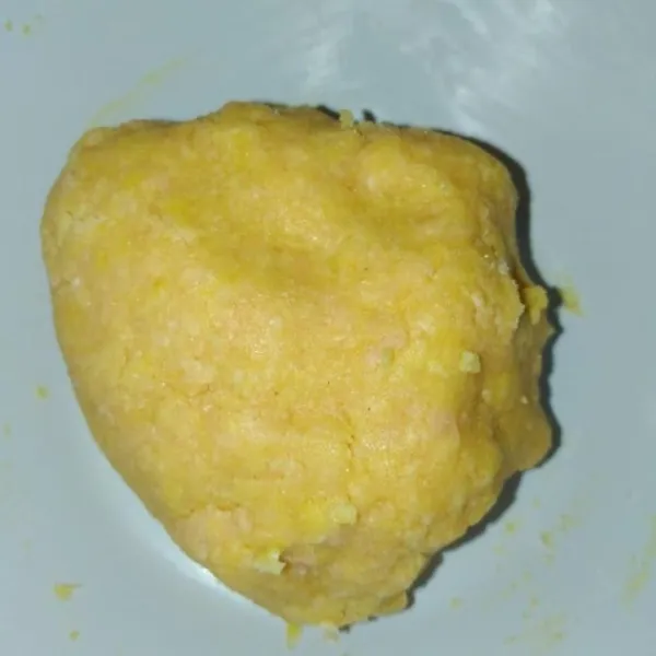 Masukkan susu sedikit demi sedikit hingga adonan bisa dipulung.