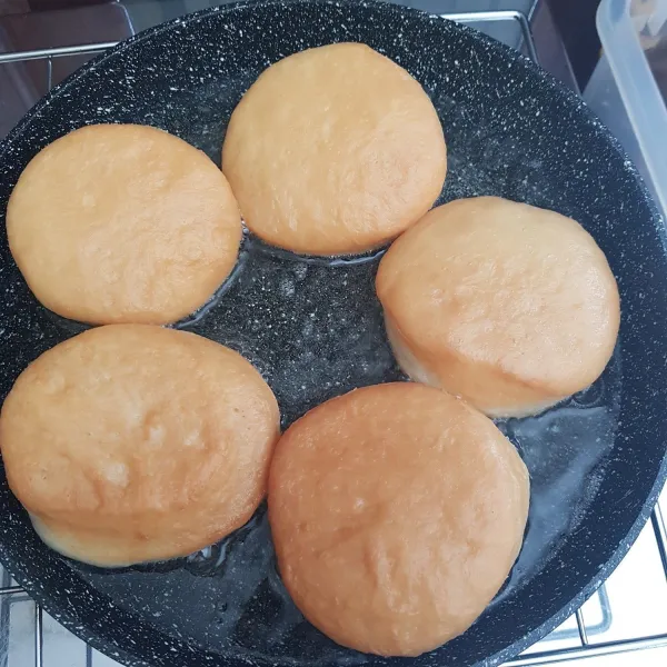 Panaskan minyak goreng kemudian goreng donat yang sudah mengembang dengan api sedang cenderung kecil hingga satu bagian matang kecoklatan, lalu balik bagian sisi lainnya. Jangan membolak-balik donat saat menggoreng karena akan sangat menyerap banyak minyak, cukup 1x balik saja.