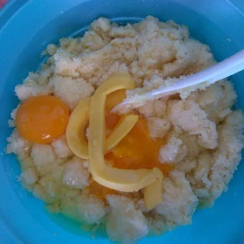 Campurkan singkong parut dengan telur, mentega dan gula pasir. Lalu aduk rata.