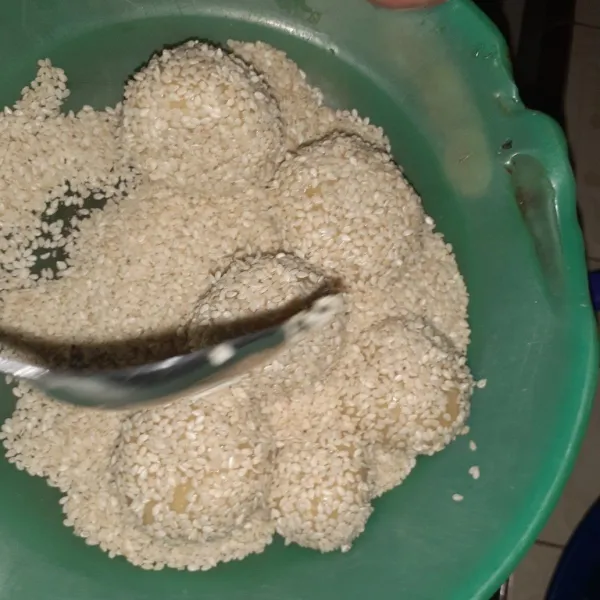 Lalu guling-guling bola-bola adonan ke dalam wijen.