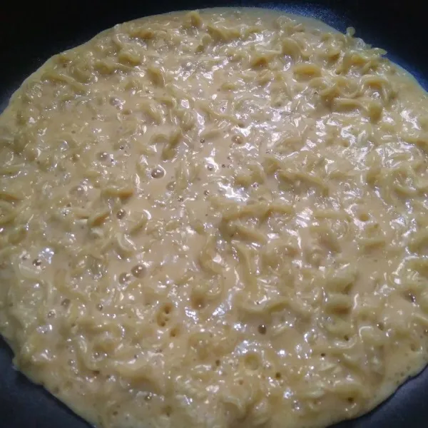 Setelah teflon benar-benar panas, tuang adonan lalu ratakan ke seluruh bagian teflon. Tutup dan tunggu hingga adonan matang.