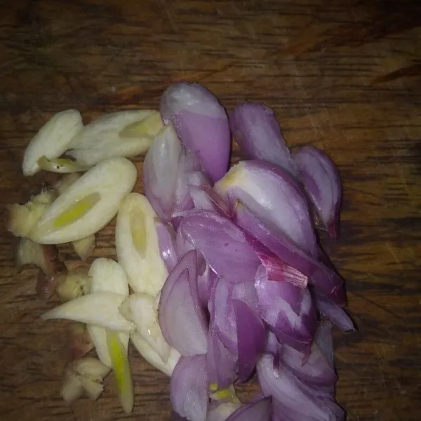 Iris tipis-tipis jahe, bawang merah, dan bawang putih.
