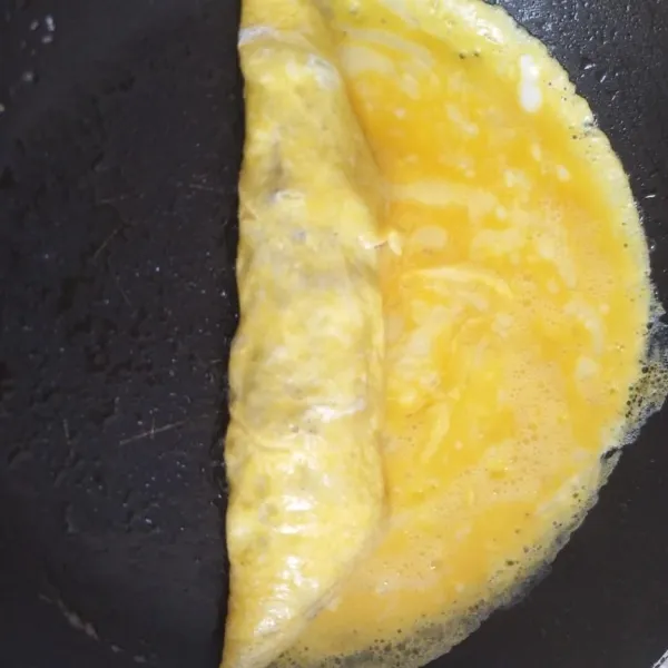 Lalu gulung telur sampai ujung, gulung hingga menutupi isian daging.