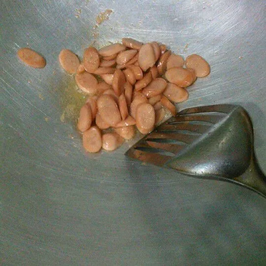 Potong serong tipis sosis kemudian goreng, angkat dan tiriskan. Kemudian haluskan cabe hijau, cabe rawit hijau, dan bawang putih. Sisihkan terlebih dahulu.
