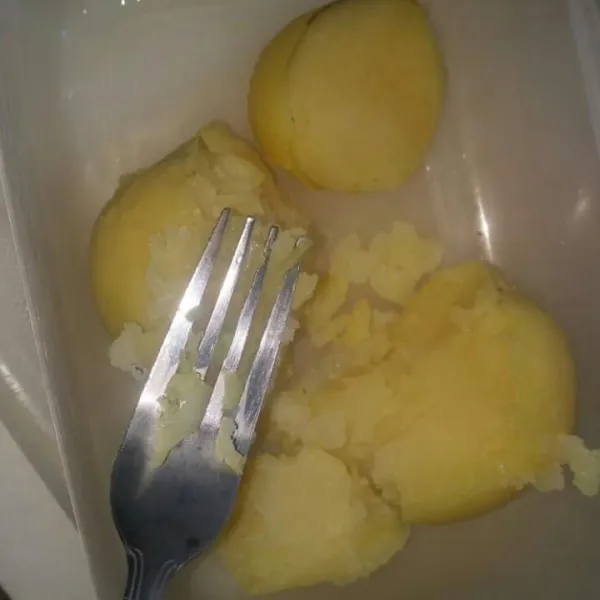 Kukus kentang sampai matang dan empuk. Kupas kulit kentang lalu haluskan sampai halus dengan garpu.