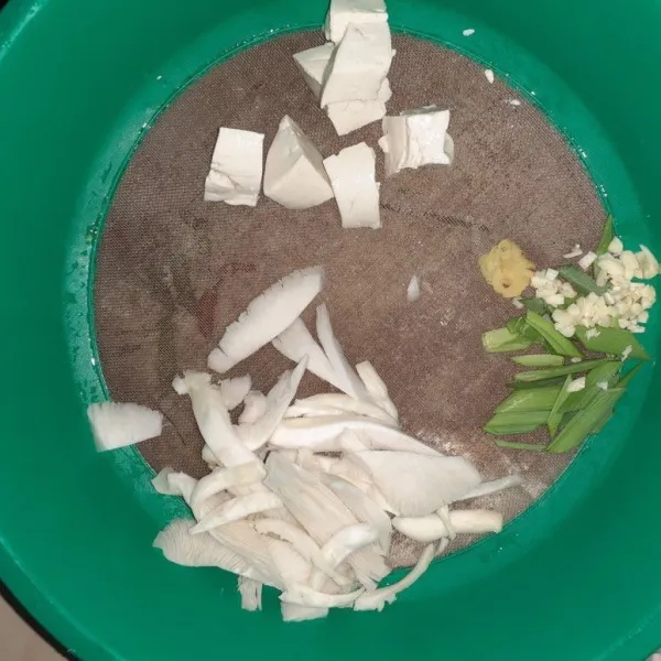 Siapkan bumbu, potong dadu tahu, iris jamur, dan daun bawang, cincang bawang putih dan geprek jahe.