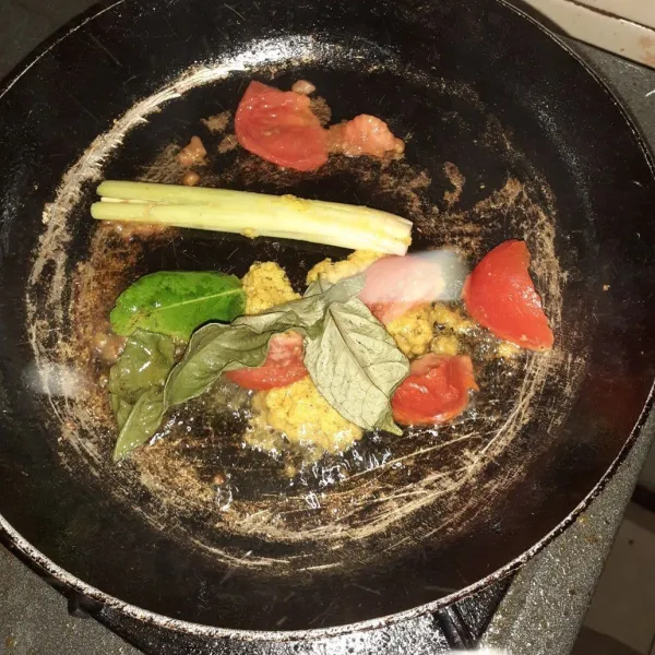 Panaskan minyak, tumiskan bumbu halus kemudian masukkan potongan tomat, sereh geprek, daun salam, dan daun jeruk. Aduk dan tunggu hingga harum.