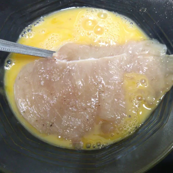 Masukkan ayam kedalam adonan telur. Balik hingga seluruh daging ayam terlumuri telur.
