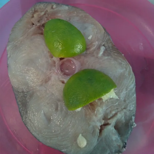 Cuci bersih ikan tengiri lalu beri 1/2 buah perasan jeruk nipis.