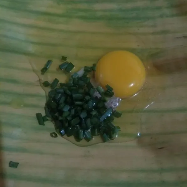 Pecahkan telur kemudian tambahkan garam, merica, dan daun bawang cincang.