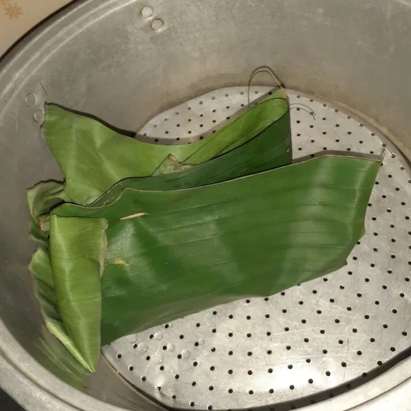 Panaskan panci, kukus bungkusan terong hingga daun pisang berubah warna dan layu.