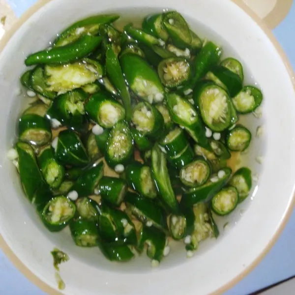 Iris cabe hijau besar dan rendam dengan air panas hingga layu, lalu tiriskan.