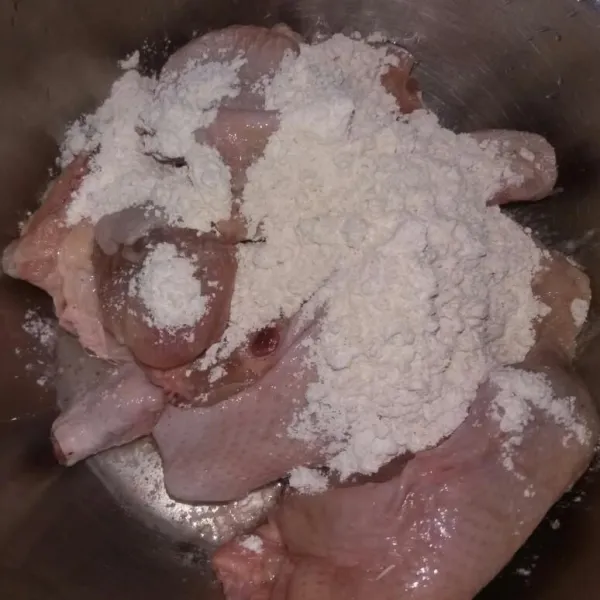 Siapkan ayam yang sudah dipotong-potong dan dicuci bersih, bubuhkan 2 sdm tepung yang susah disisihkan sebelumnya.