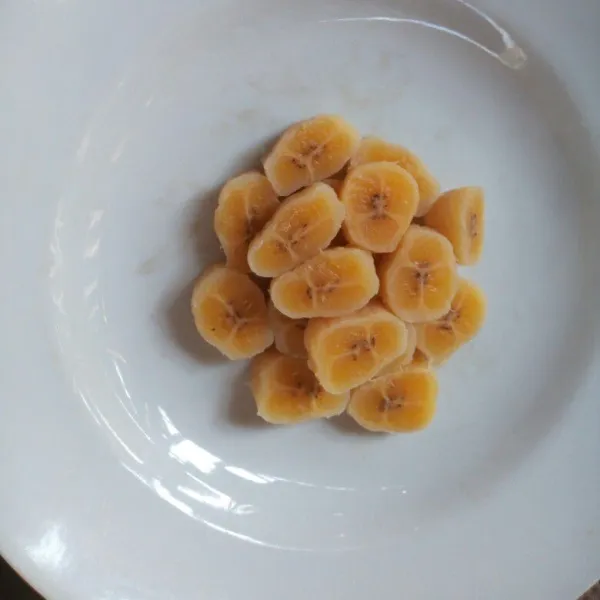 Potong pisang kemudian letakkan dalam piring saji, sisihkan terlebih dahulu.