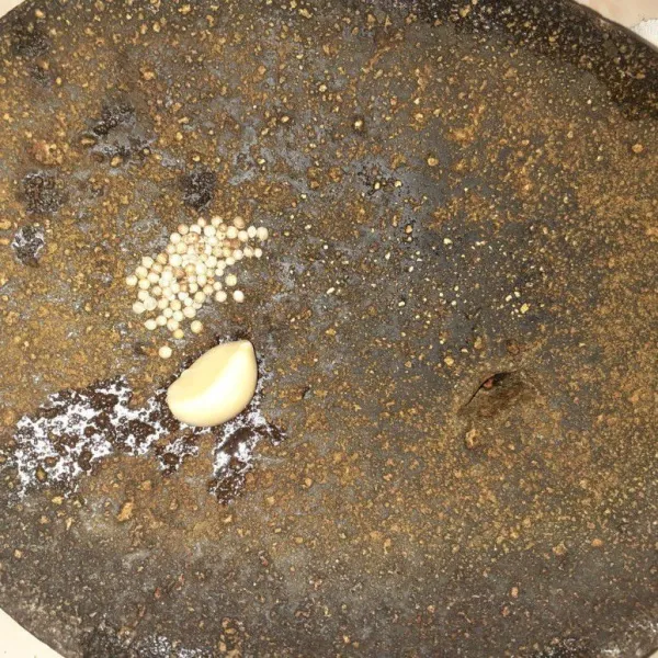 Giling bumbu halus bawang putih dan ketumbar.