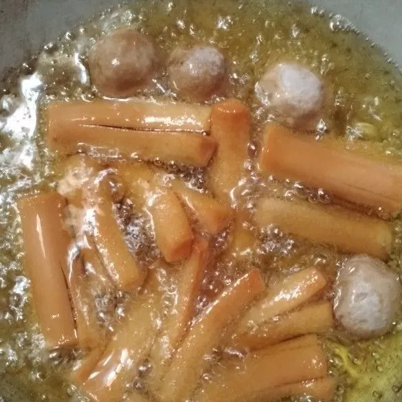 Iris bagian tengah bakso, potong menjadi 3 bagian untuk sosis iris bagian tengahnya, goreng bakso dan sosis hingga mekar.