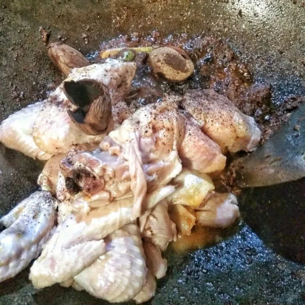 Masukkan ayam dan buah keluak yang masih ada kulitnya, aduk hingga ayam kaku.