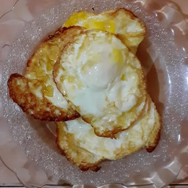Goreng telur ceplok setengah matang.