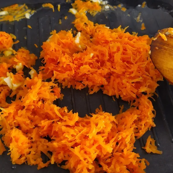 Panaskan minyak di wajan anti lengket kemudian tumis bawang putih hingga harum, lalu masukkan wortel aduk hingga wortel layu.