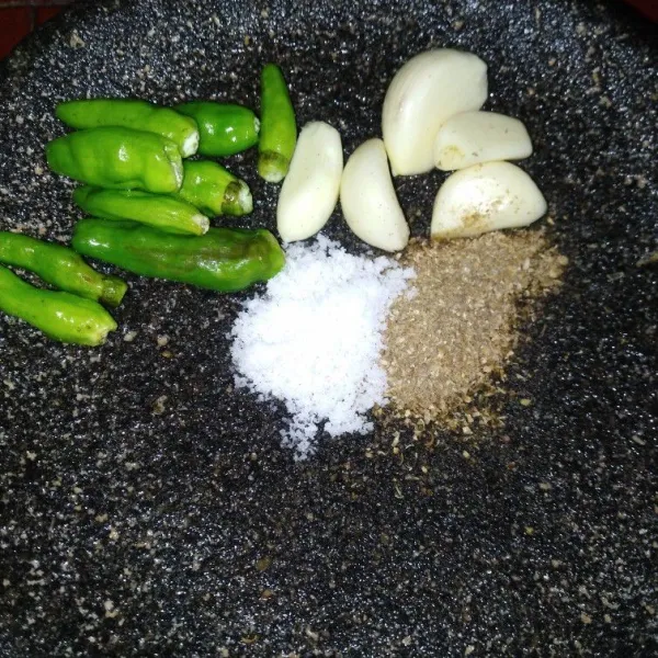 Haluskan bawang putih, ketumbar bubuk, garam, dan cabe hijau kecil, setelah itu tambahkan air asam.