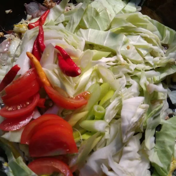 Masukkan kol, daun bawang, tomat, dan cabe rawit utuh, aduk-aduk hingga sayuran layu.