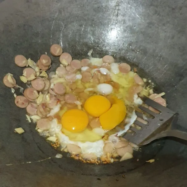 Tumis bawang merah dan bawang putih, lalu sosis dan telur. Aduk-aduk hingga merata.