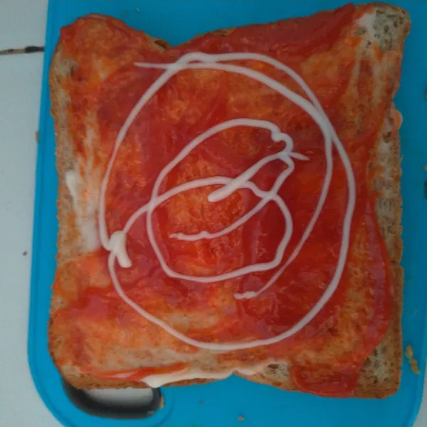 Beri mayonaise dan saus sambal diatasi roti.