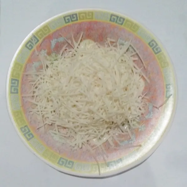 Parut keju cheddar.