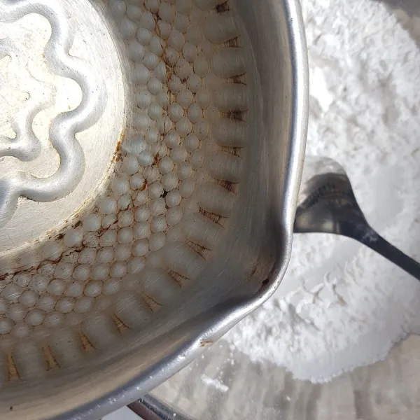 Masukkan sedikit demi sedikit air panas ke dalam campuran tepung. Aduk cepat menggunakan spatula, aduk dan tuang air mendidih hingga adonan cilok bisa di pulung.
