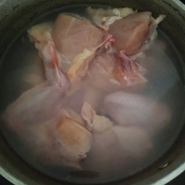 Cuci ayam dengan air mengalir, lalu rebus dengan air garam selama 15-20 menit.