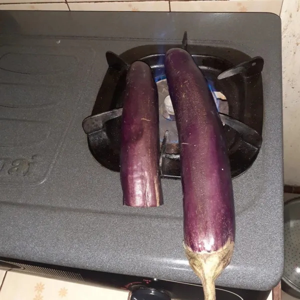 Panaskan kompor, panggang terong.