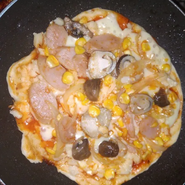 Masak dengan teflon kurang lebih 8 menit, masak dengan di tutup. jangan lupa sesekali di lihat pizza sebelah bawah apa sudah coklat atau belum, jika dikira sudah pas, angkat dan sajikan.